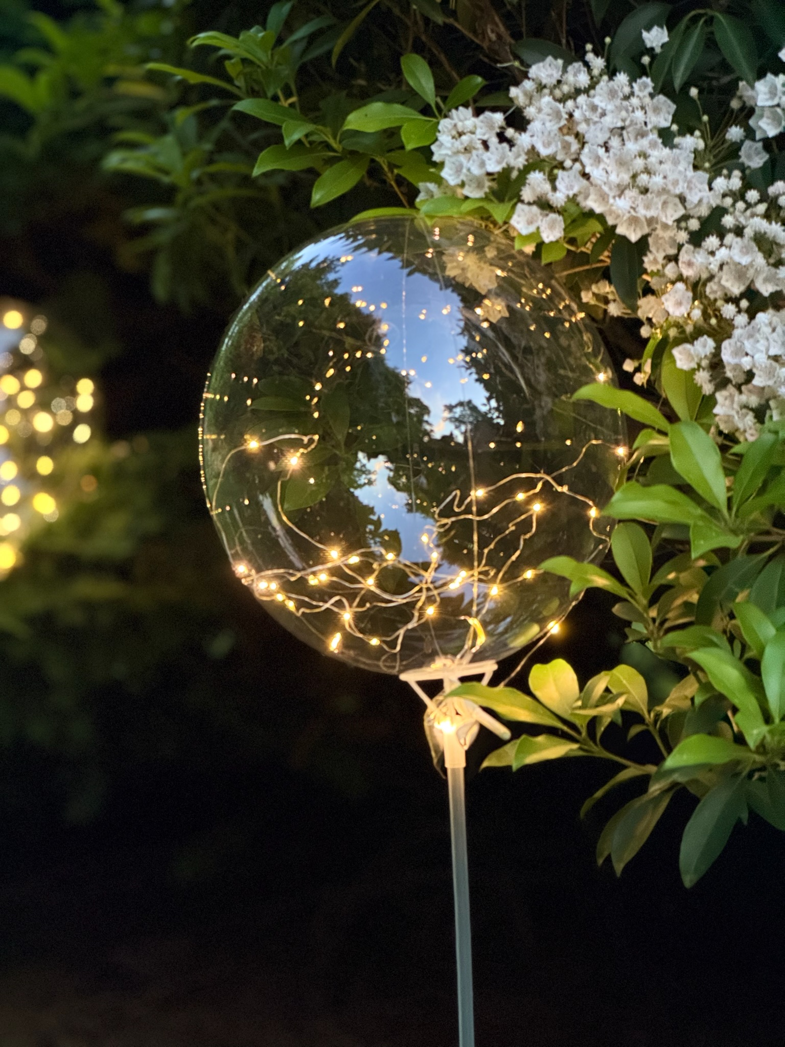 LED fairy light balloons along garden stairway at dusk